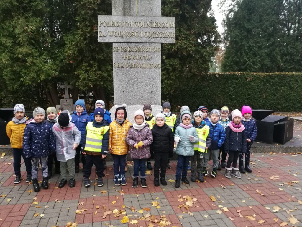 dzieci ustawione na tle pomnika