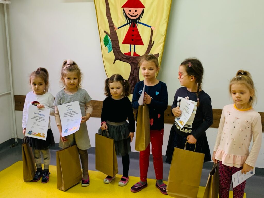 sześć dziewczynek , laureatek konkursu plastycznego stoi z odebranymi nagrodami i dyplomami
