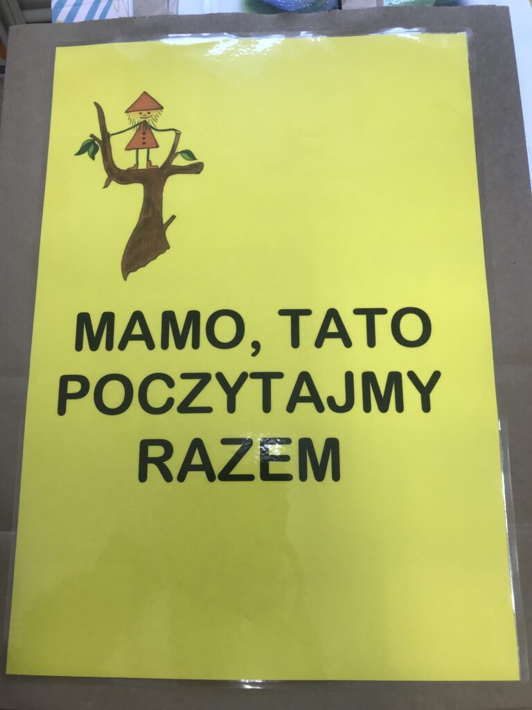 Zdjęcie prezentuje torbę z napisem MAMO TATO POCZYTAJMY RAZEM. To torebka na wybrana przez siebie ksiązkę, która będą zabierały do swojego domu , żeby poczytac ją wspólnie z mamą i tatą. 