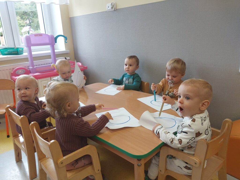 Grupa dzieci koloruje szablon kropki.