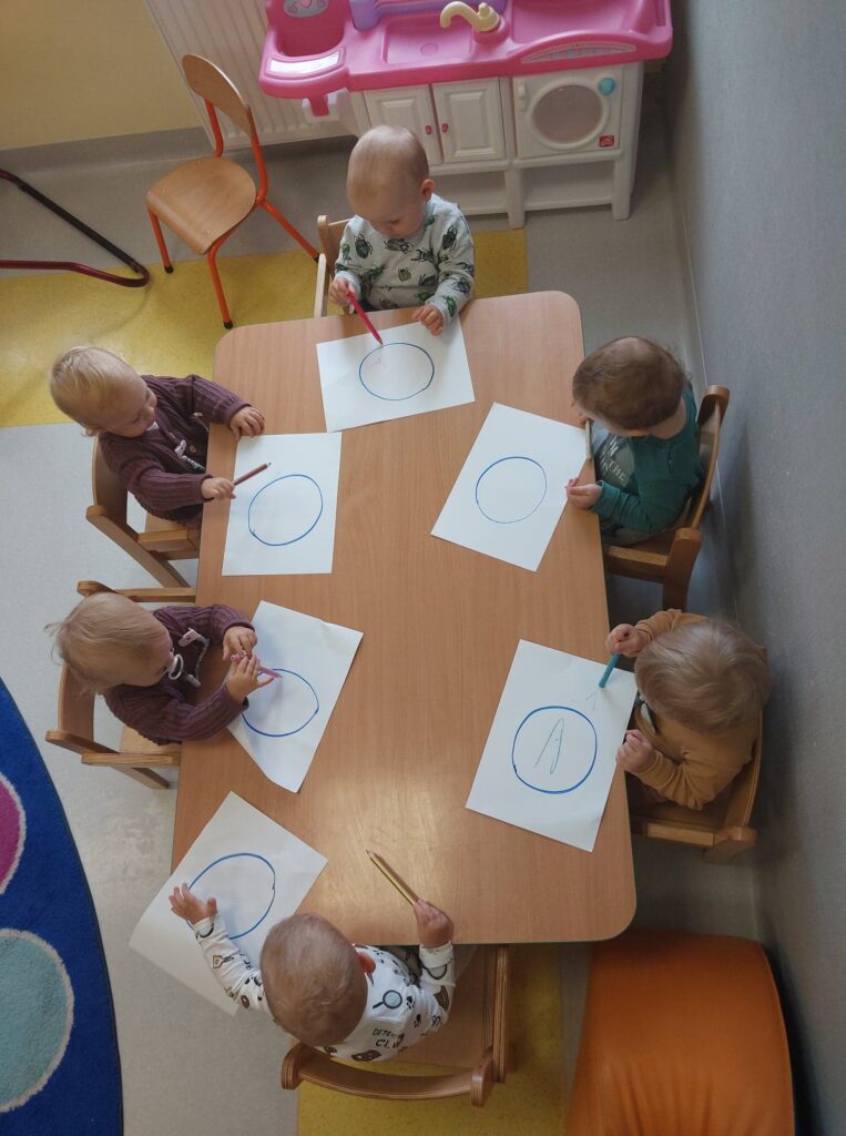 Grupa dzieci koloruje szablon kropki.