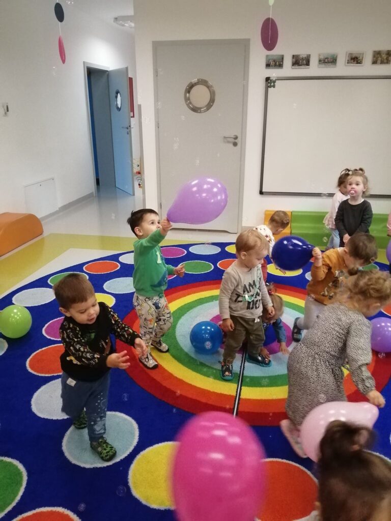 dzieci patrzą i bawią się balonami w powietrzu unoszą się bańki