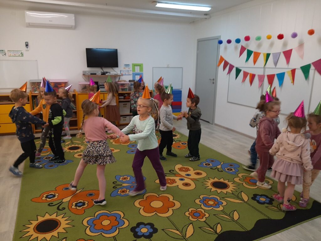 dzieci tańczą w parach na sali w przedszkolu 