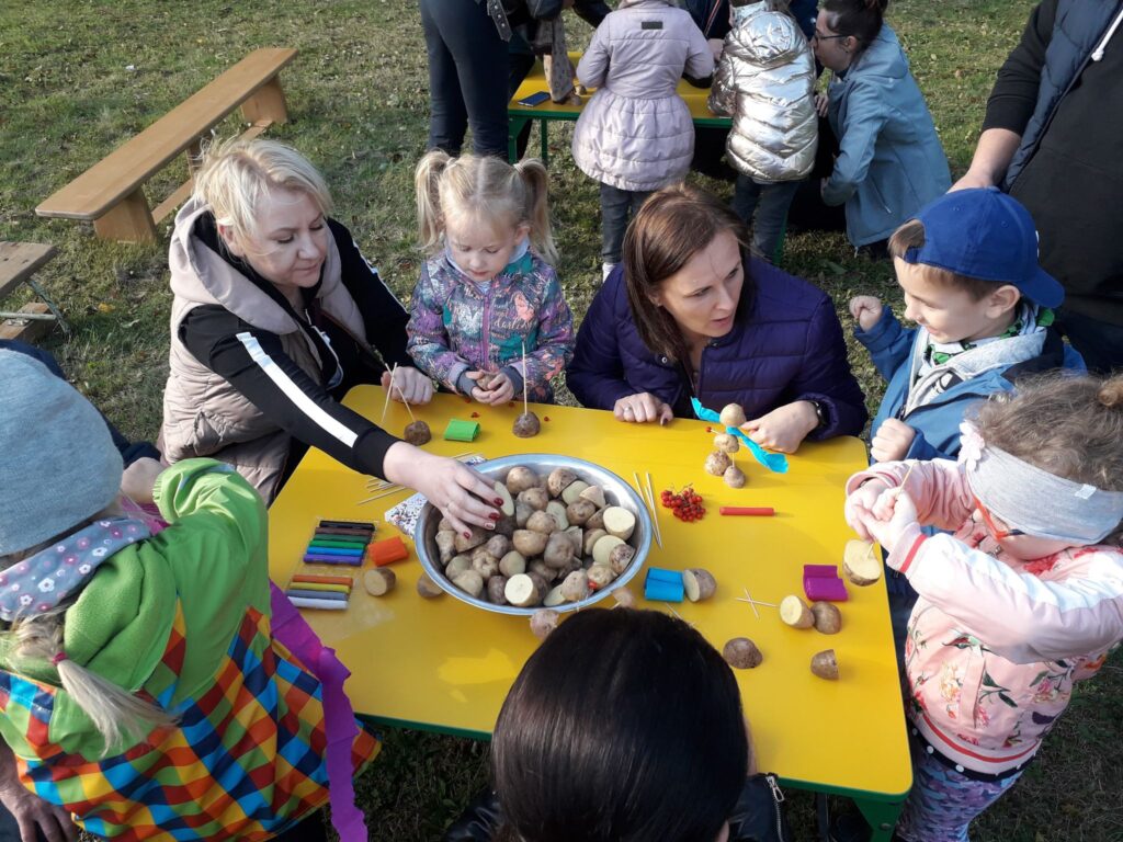 Dzieci i rodzice konstruują ludziki z ziemniaków.