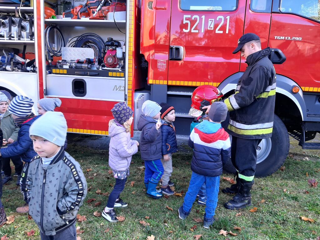 dzieci oglądają sprzęt który pokazuje strażak 