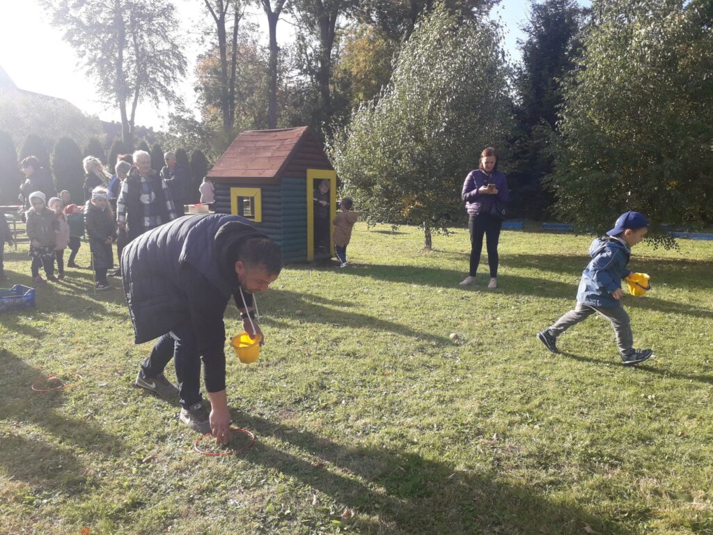 Tata z synem sadzą ziemniaki na wyścigi podczas święta pieczonego ziemniaka.