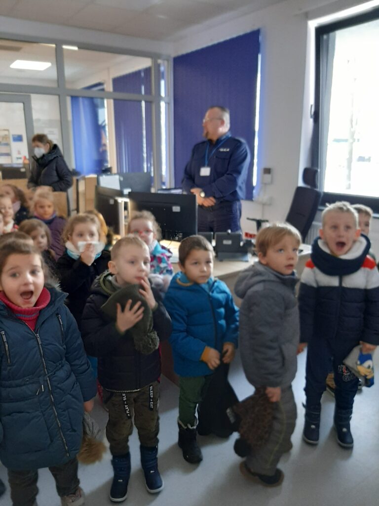 Dzieci w dyżurce Komendy Policji w Sławnie wraz z Panem policjantem .