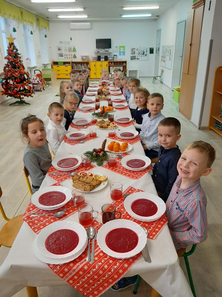 Dzieci z grupy II siedzą przy wspólnym stole podczas uroczystego obiadu.