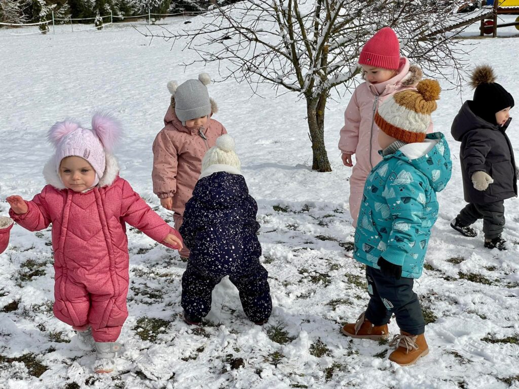 Dzieci z grupy Krasnali bawią się na śniegu.