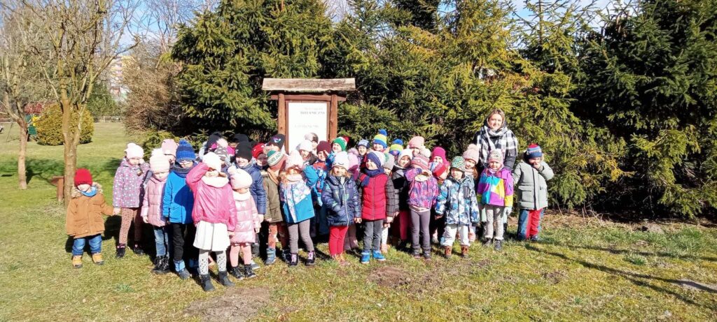 Na zdjęciu stoi grupa dzieci z zaprzyjażnionego przedszkola. Dzieci odwiedzają nasz ogród , przyszły zwiedzić scieżke edukacyjną