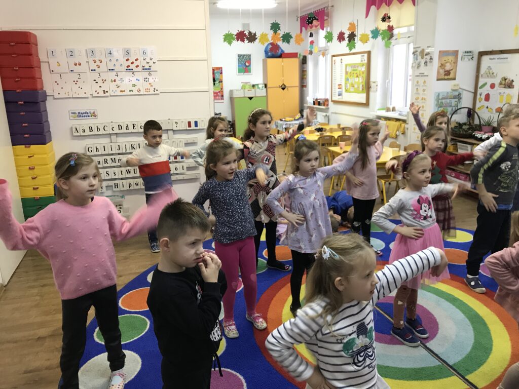 dzieci tańczą i bawią sie  w zabawy ruchowo nasladowcze z okazji andrzejek