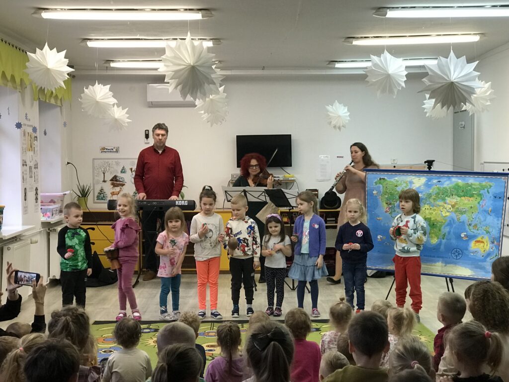 Nasza przedszkolna orkiestra. Dzieci graja na instrumantac w rytm melodii zagranej przez muzyków z Filharmonii.