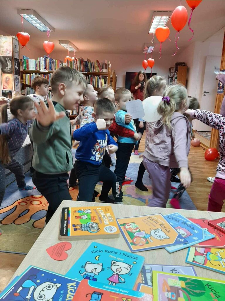 Wesoła kocia gimnastyka. Dzeci w Bibliotece bawią się z oazji Dnia Kota. 