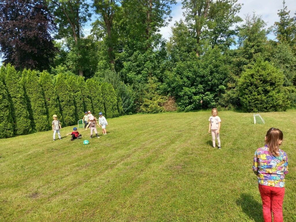 Przedszkolaki uczestniczą w meczu piłki nożnej.