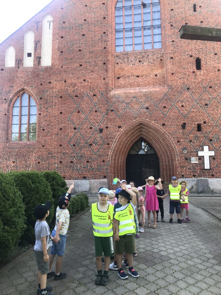 przedszkoalki stoja przed dużym Kościołem w mieście Sławno.