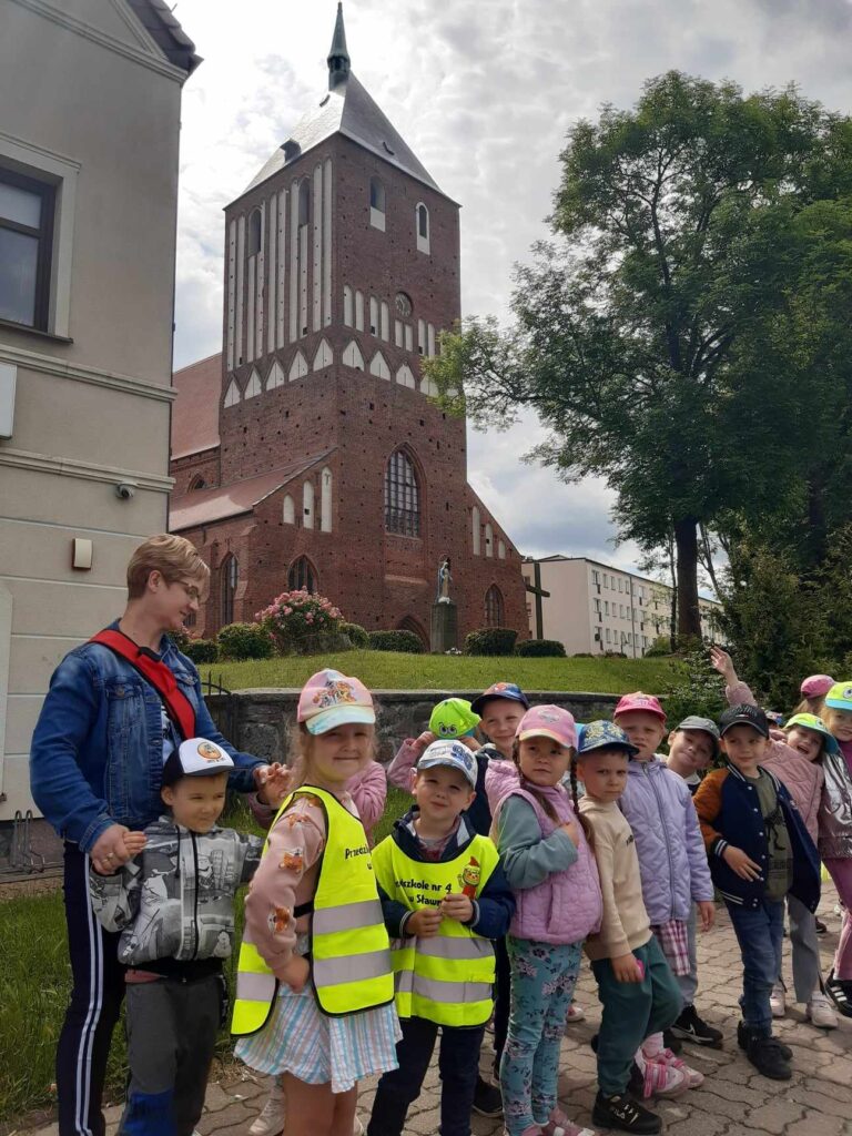 Dzieci pozują do zdjęcia na tle Kościoła.