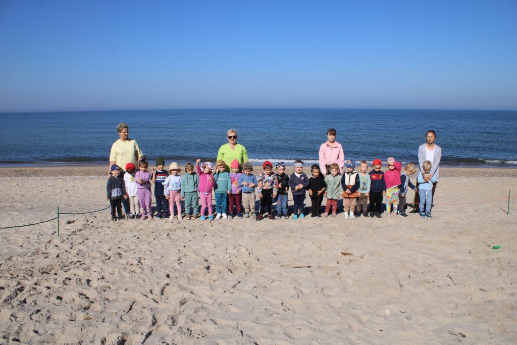 DZIECI POZUJĄ DO ZDJĘCIA NA PLAŻY W JAROSŁAWCU