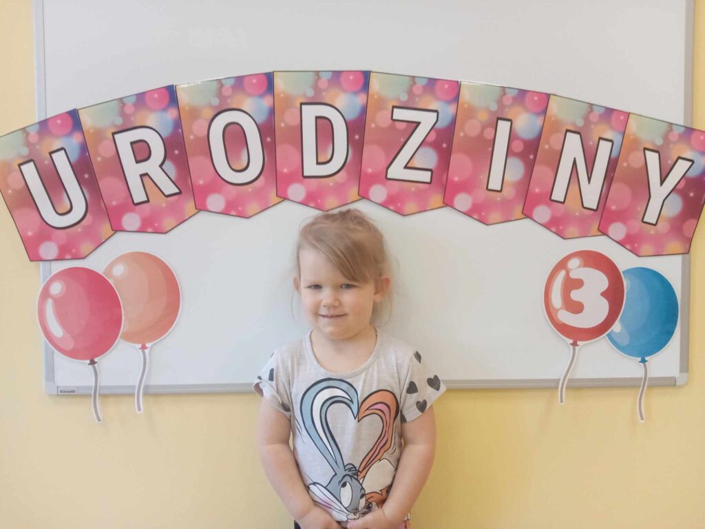 DZIEWCZYNKA POZUJE DO ZDJĘCIA URODZINY 3 