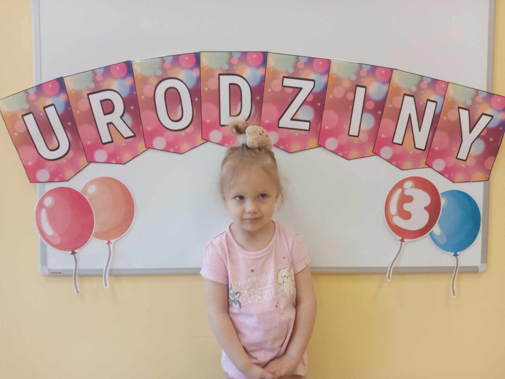 DZIEWCZYNKA POZUJE DO ZDJĘCIA URODZINY 3 
