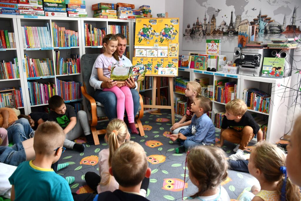 Pan Michał czyta książkę dzieciom z grupy starszaków.