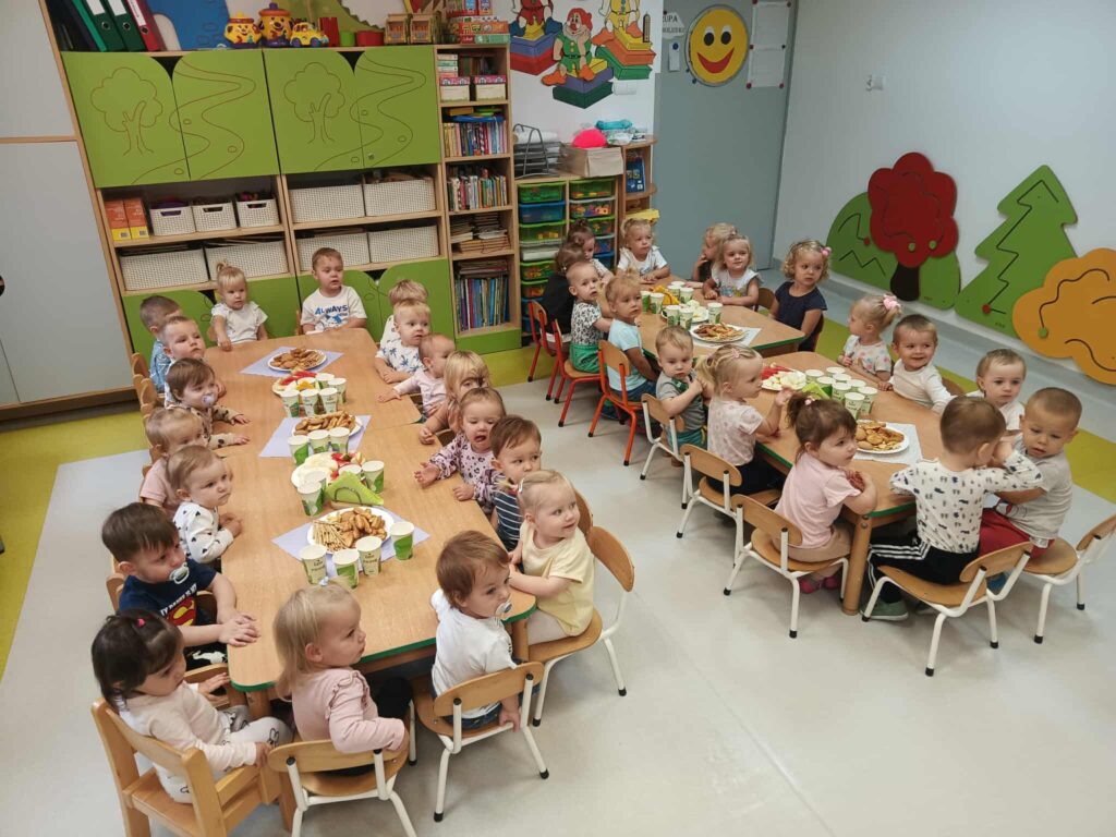 DZIECI JEDZĄ SŁODKI POCZĘSTUNEK