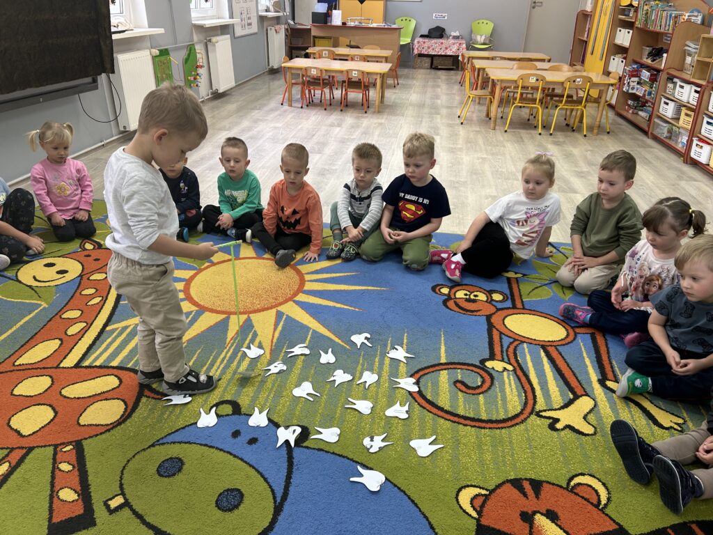 Chłopiec przy pomocy magcznej wędki z magnesem usuwa brudne zęby- zabawa profilaktyka mycia zębów