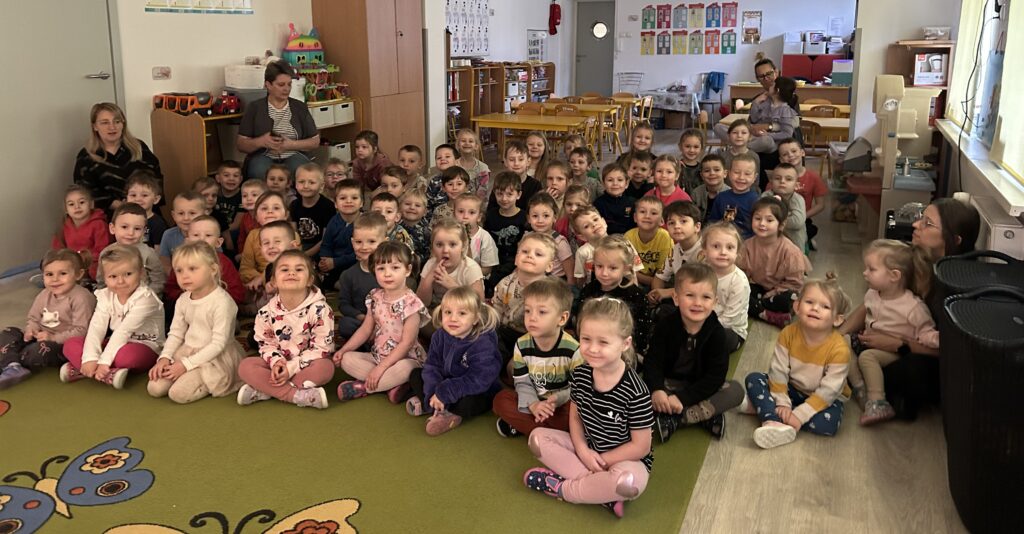 Wszystkie przedszkolaki siedza na dywanie w sali i oczekują na przedstawienie-teatr cieni 
