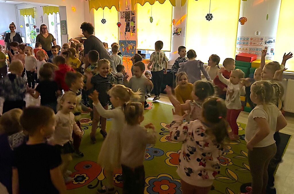 Zabawa taneczna przy muzyce z okazji ANDRZEJEK. Wszytskie dzieci tańcza w sali przedszkolnej 