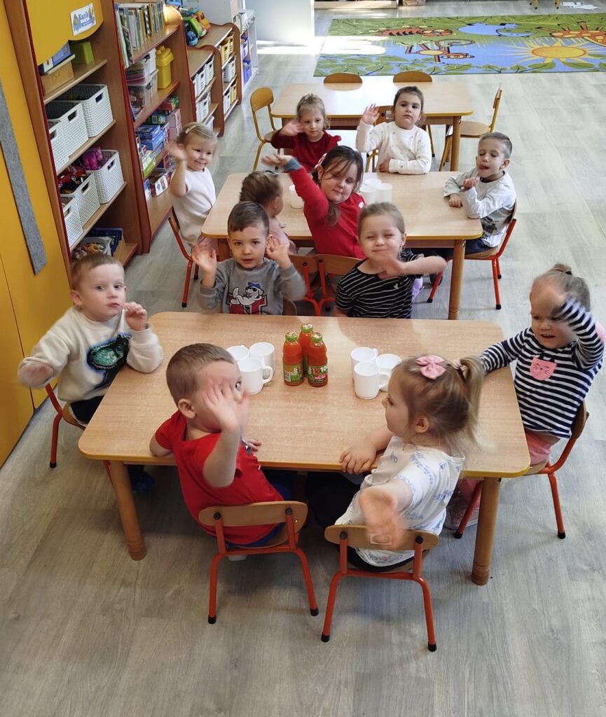 Nasze przedszkolaki siedzą w sali przy stolikach. Przed dziećmi stoja pyszne zdrowe KUBUSIOWE soki. Dzieci rozmawiały wcześnije o konieczności picia zdrowych owocowych soków, realizując program Kubusiowi Przyjaciele Natury 
