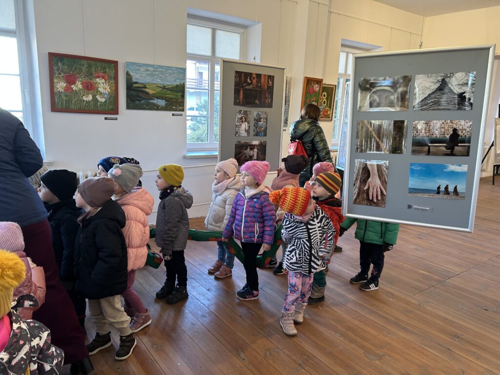 dzieci oglądają prace malarskie, zdjęcia rzeźby na wystawie w swoim mieście zorganizowana w SDK