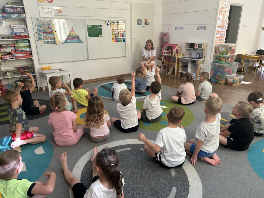 Dzieci siedza w swojej sali na dywanie. przed nimi zaproszony gośc - INTENDENTKA , ktora opowiada o zdrowych produktach jakie kupuje, aby przygotowac dzieciom zdrowe dania w przedszkolu. Dzieci słuchaja ciekawostek , i na tablicy ukladaja zdrową piramidę żywieniową. 